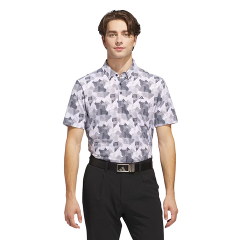 A man stands facing forward in the Adidas Mens Go-To Printed Polo Shirt in White/Collegiate Navy, paired with black pants and a black belt, against a plain white background.