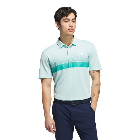 A man with short dark hair and tattoos on his left forearm wears the Adidas Mens Performance Chest Stripe Print Polo Shirt in Flash Aqua, paired with navy pants and a black belt, looking slightly to the side.