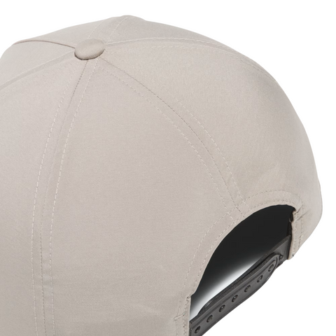 A close-up of the Adidas Mens Tour Five-Panel Hat in Putty Beige shows stitching details, breathable performance fabric, and an adjustable gray plastic snapback strap.