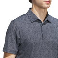 A man wears the Adidas Mens Ultimate365 Bunker Polo Shirt in Collegiate Navy, a short-sleeved, collared, patterned design, shown from shoulders to mid-torso against a white background.