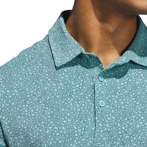 Close-up of a person wearing the Adidas Mens Ultimate365 Bunker Polo Shirt in Pure Teal, featuring a subtle abstract squiggly line pattern and moisture-wicking fabric. Only the lower face, neck, and upper chest are visible.
