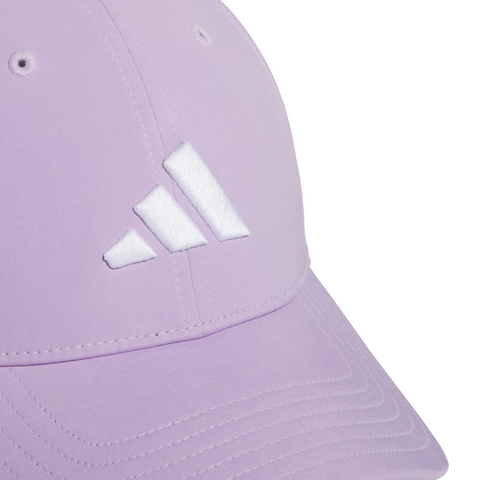 The Adidas Womens Tour Badge Cap in pastel purple features a white Adidas logo, visible stitching, ventilation eyelets, and moisture-wicking fabric for comfort during golf.