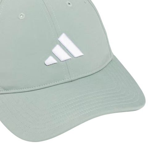 The Adidas Womens Tour Badge Cap is a light green golf cap with a white Adidas logo, visible stitching, crown ventilation eyelets, and built-in sun protection for comfort on sunny days.