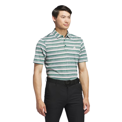 A man in an Adidas Two-Colour Striped Men's Polo Shirt, featuring moisture-wicking fabric, black pants, and a black belt stands against a white background.