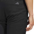 A close-up shows a person in Adidas Ultimate365 Men’s Golf Pants, featuring a gray logo above the back pocket—these moisture-wicking pants offer comfort and style for golfers.
