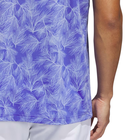 A person is shown from the back wearing an Adidas Ultimate365 Mesh Print Mens Polo (2XL only) featuring a white palm leaf pattern on a purple background, paired with white pants.