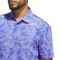 A person is shown from the shoulders up wearing a purple Adidas Ultimate365 Mesh Print Mens Polo (2XL only) with a white palm leaf pattern, against a white background.
