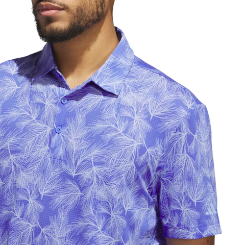 A person is shown from the shoulders up wearing a purple Adidas Ultimate365 Mesh Print Mens Polo (2XL only) with a white palm leaf pattern, against a white background.