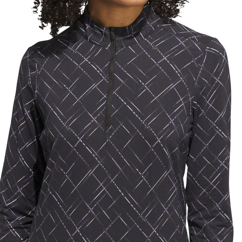A person wears an Adidas Ultimate365 Printed Quarter-Zip Long-Sleeve Polo Shirt in Black/Powder Plum, featuring a geometric purple and white line pattern. Their face is partially out of frame.