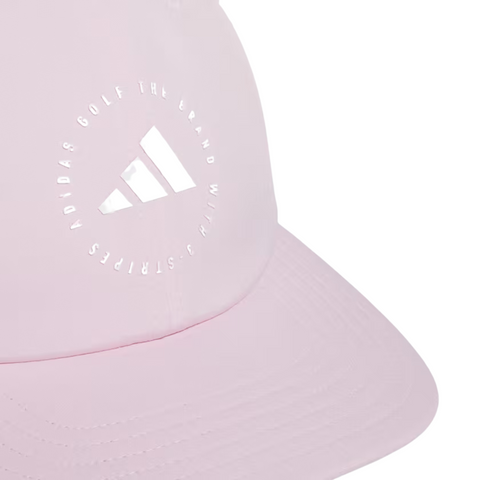 A close-up of the Adidas Womens Crisscross Hat in Clear Pink from golf360nz, featuring a white logo and circular ADIDAS GOLF THE BRAND WITH 3 STRIPES text on the front panel, made with moisture-wicking fabric for comfort.