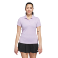 A woman wears the Adidas Women’s Ottoman Short Sleeve Polo Shirt in Powder Plum, paired with a black skirt. She stands smiling slightly, showing arm tattoos, and poses against a white background.