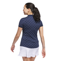 A woman with dark hair in a ponytail is seen from behind wearing the Adidas Womens Ultimate365 Jacquard Short Sleeve Polo Shirt in Collegiate Navy, standing against a white background.