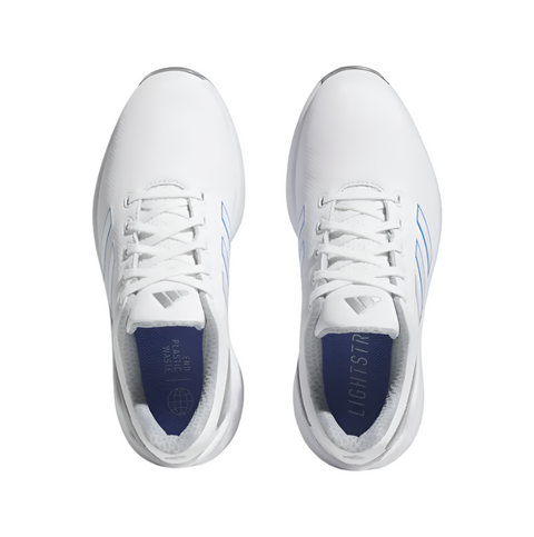Top view of Adidas Womens ZG23 Golf Shoes White/Blue/Silver (US 7), an ultralight white pair with blue accents, subtle tongue logo, and insoles marked LIGHTSTRIKE and MADE WITH RECYCLED MATERIALS. Brand: Adidas.