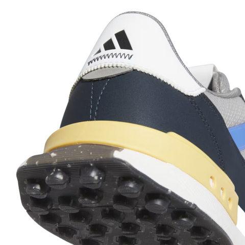 Close-up rear detail of the Adidas S2G SL 24 Wide Golf Shoes, showcasing the contrast between the dark navy heel, yellow heel support, and white upper with visible stitching. The Adidas logo is prominently displayed on the back heel tab, and the textured outsole with small grip studs is visible at the bottom for traction.
