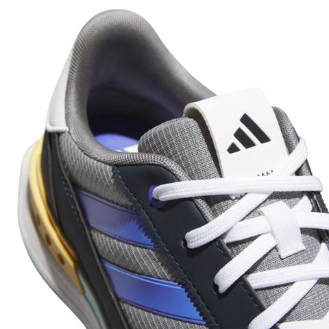 Close-up of the top detail of the Adidas S2G SL 24 Wide Golf Shoes. The image highlights the white laces, the Adidas logo on the tongue, and the mix of materials including a grey mesh upper and blue synthetic stripes. The heel features a mustard yellow accent, adding contrast to the otherwise neutral-toned design.