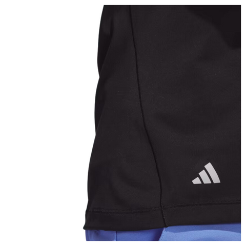 Close-up of the lower front section of the Adidas women's performance golf hoodie in black. The silver Adidas logo is visible near the hem, showcasing smooth, lightweight fabric. The hem is neatly stitched.