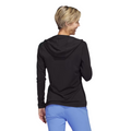 Back view of model wearing Adidas women's performance golf hoodie in black. The hoodie has a relaxed fit, long sleeves, and a lightweight fabric. The model is also wearing light blue golf pants.