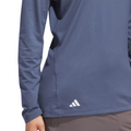 Adidas women's performance golf hoodie, slate blue, lightweight moisture-wicking fabric, close up front view on model with white Adidas logo on lower hem.