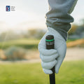 A close-up of a golfer’s gloved hand gripping a club, with a blurred golf course behind. The Arccos logo and Arccos Smart Sensors Gen 4 Green for automatic shot tracking appear in the upper left corner.