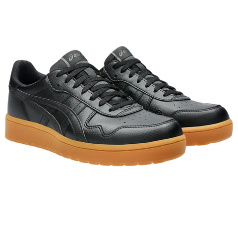 Pair of black Asics Japan S Men's Golf Shoes with leather uppers, black laces, and tan rubber soles on a white background.