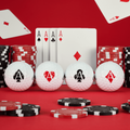 The Callaway 2025 Limited Edition Supersoft Aces Golf Balls feature four balls, each with a unique ace suit symbol, set against a red poker-themed backdrop—perfect for golfers seeking soft feel and exclusive style.