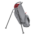 The Callaway Fairway C HD Stand Bag stands upright on extended black legs, featuring a gray and red design with multiple compartments and handle. This lightweight Callaway golf bag combines style and functionality for golfers.