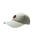 The Callaway Women’s Heritage Twill Golf Cap is light gray with visible stitching, a round brown leather patch logo on the front, sun protection, and an adjustable fit, showcased on a white background.