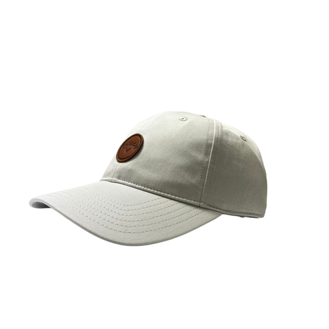 The Callaway Women’s Heritage Twill Golf Cap is light gray with visible stitching, a round brown leather patch logo on the front, sun protection, and an adjustable fit, showcased on a white background.