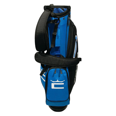 The Cobra 2025 Signature Stand Bag in Electric Blue/White/Black features a padded shoulder strap, zippered pockets, and white crown logo on the front pocket—lightweight and stylish from Cobra. Shown upright on a white background.