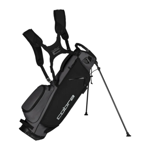 The Cobra 2025 Ultralite Carry Bag in Black/Dusky Grey features dual shoulder straps, multiple pockets, two extended support legs, and the Cobra logo for comfortable carrying on the course.