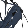 A close-up of the Cobra Ultralite Pro Stand Bag 2025, a blue lightweight golf bag by Cobra, shows a smartphone in the partially open zippered pocket. The bag features shoulder straps, metal zippers, and stand legs.