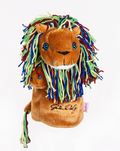 A plush lion hand puppet with blue eyes, white felt tooth, and a multicolored yarn mane in blue, green, yellow, and red. Inspired by Daphnes Animal Golf Headcovers by Daphne; features embroidered text and a yarn-tipped tail.