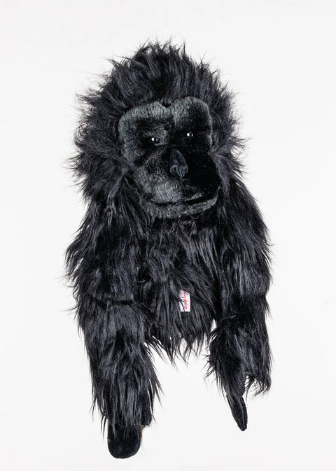 A black plush gorilla toy with long, shaggy fur lies flat on a white background, resembling a Daphnes Animal Golf Headcover by Daphne designed as an animal-themed headcover for golf clubs.