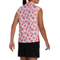 Back view of a sleeveless FootJoy golf shirt with a red and pink floral pattern on a white background. Paired with a black skirt, the shirt showcases a bold, eye-catching design perfect for summer golfing.