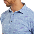 Close-up of the FootJoy Golf Doodle Polo in storm blue, featuring an abstract doodle pattern in white and purple. The shot focuses on the collar and upper chest, highlighting the button-up design and smooth fabric texture.