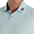 Close-up of the FootJoy Tweed Texture Polo collar in mint green with navy and pink speckles. The collar displays the FootJoy logo on the left, with a buttoned placket and visible navy inner lining for contrast.