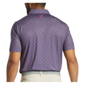 A man is seen from behind wearing a purple FootJoy Flying Wasp Men’s Lisle Polo and light-colored pants. This polo by FootJoy has a repeating mini design, logo below the collar, and moisture-wicking fabric for comfort.