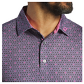 Close-up of a person wearing the FootJoy Flying Wasp Men’s Lisle Polo by FootJoy, a purple men’s golf shirt with small pink and black triangles, a pink inner collar, an embroidered pink logo, and stylish moisture-wicking fabric.