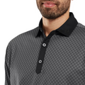 A man models the FootJoy Men's Checker Print Lisle Polo in Black/Grey, featuring a black collar and lightweight Lisle fabric. Only his lower face, neck, and upper torso appear in the image.