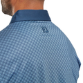 Close-up of the back of a person’s neck and shoulders wearing the FootJoy Men's Checker Print Lisle Polo in Dark Denim/White—a blue checkered performance golf shirt with a dark blue collar and embroidered FJ logo below the collar.