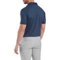 A man stands facing away, wearing a FootJoy Men's Etched Texture Print Lisle Polo in navy with light gray pants. The golf shirt emphasizes his upper back and shoulders, while his arms rest relaxed at his sides.
