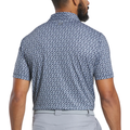 A man faces away wearing the FootJoy Men's Floral Sketch Print Lisle Polo in navy and white, tucked into light gray pants with a matching belt.