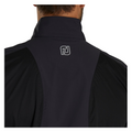 Close-up of the back of a person wearing the FootJoy Men’s HydroLite X Rain Jacket with a high collar. The white FJ logo appears at the upper center, highlighting this premium waterproof golf jacket from FootJoy.