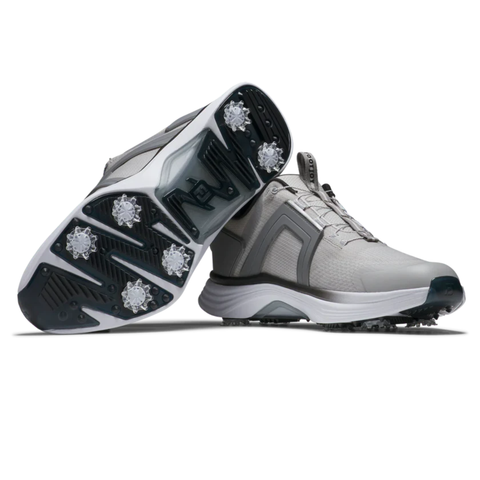 A pair of FootJoy Men's Hyperflex Boa Golf Shoes in Grey/White are shown, with one upright and the other tilted to reveal the spiked sole and grip pattern, emphasizing the advanced BOA Fit System for a secure, comfortable fit.