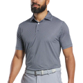 A man with a trimmed beard wears a FootJoy Mens Lisle Houndstooth Geo Print Polo in black, tucked into light gray pants with a matching belt. His head is partially out of frame.
