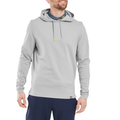 A man smiles and looks to the side, dressed in a light gray FootJoy Men's Ottoman Jacquard Pullover Hoodie layered over a patterned blue collared shirt and paired with dark blue pants.