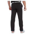 A person is shown from the back against a white background, wearing FootJoy Mens Par Trousers in black with moisture-wicking fabric, paired with a white belt and white shoes.
