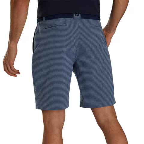 A man, seen from the back with arms relaxed, wears blue pinstriped FootJoy Men’s Performance Lightweight Shorts and a dark belt.