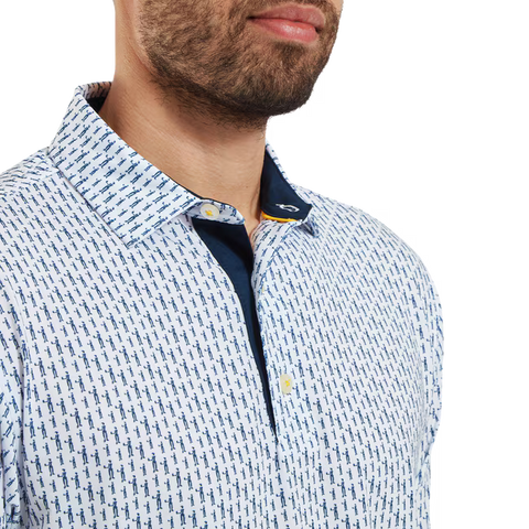 A man, shown from the chest up with a trimmed beard, wears the FootJoy Mens Pique Solid Figure Print Lisle Polo in White/Navy, featuring a blue geometric pattern and navy inner collar. This moisture-wicking shirt keeps you cool and comfortable.