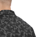 Close-up of a man's neck and shoulders in the FootJoy Men's Pop Camo Lisle Polo in Black/Grey, featuring a camo pattern, moisture-wicking fabric, and an embroidered FootJoy logo below the collar.
